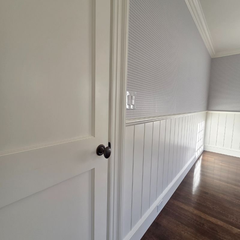 Elegant white wall paneling with raised trim in a sophisticated living room