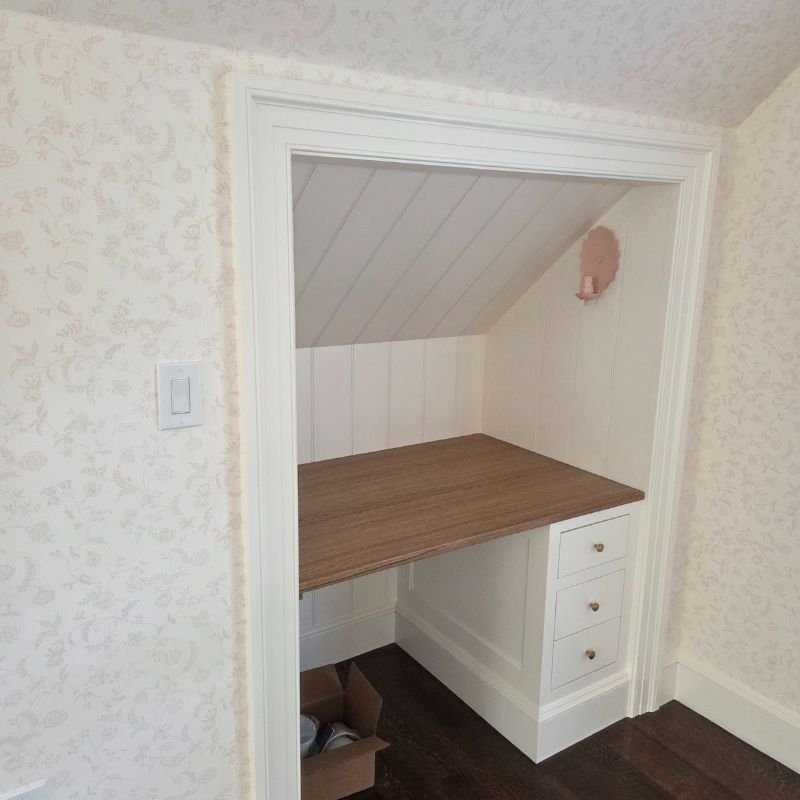 Custom built-in wall unit combining shelves, cabinets, and a built-in desk