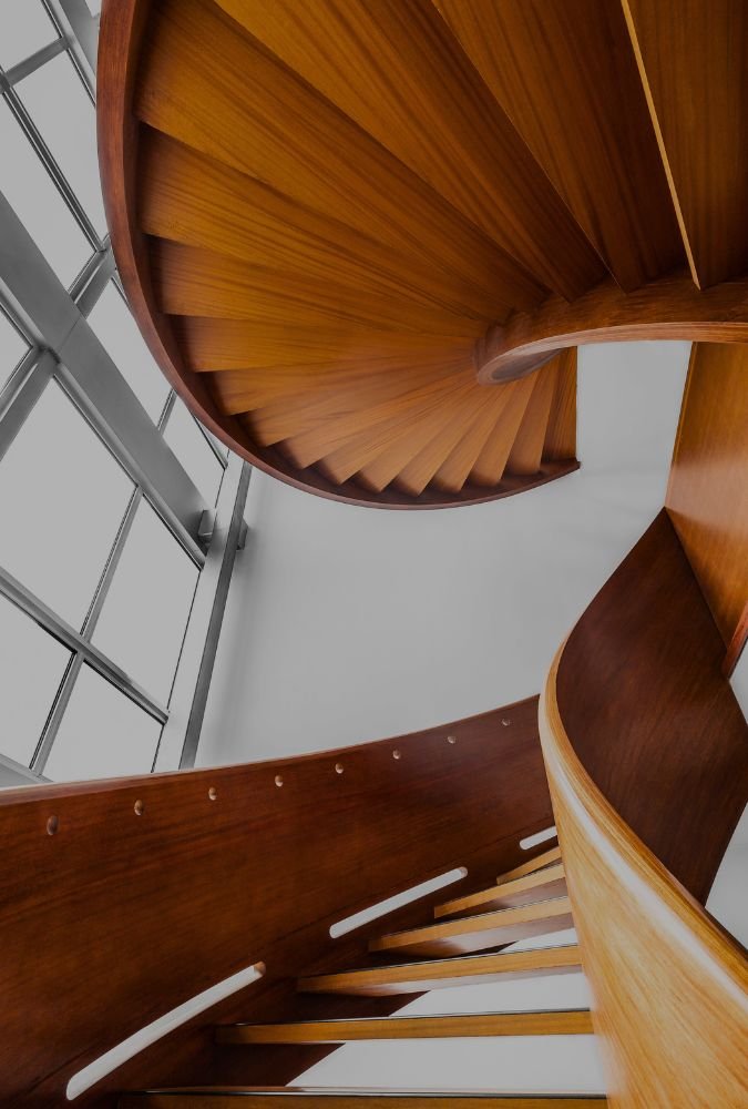 Luxury custom spiral staircase with natural wood treads crafted by Innovation Carpentry in South Shore